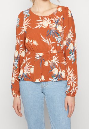 Blusa floreale color ruggine con maniche lunghe, dotata di vita a peplum, scollatura rotonda e vivaci motivi floreali blu e crema.