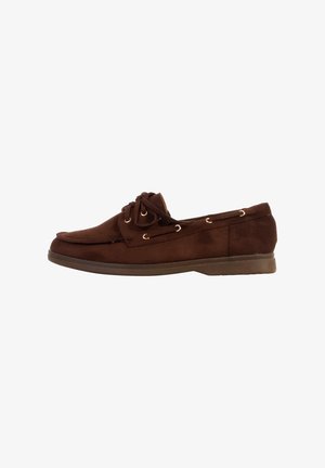 Mocassino da uomo in camoscio marrone con lacci frontali, cuciture moc toe e suola in gomma piatta, visto dal lato esterno.