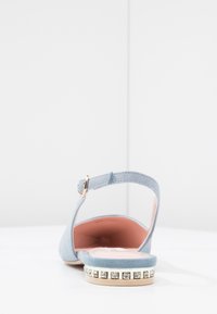 Sandalo in suède blu chiaro con cinturino posteriore, fodera interna rosa e un dettaglio decorativo di perline sulla suola.