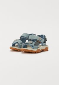 Ljusblå sandaler med justerbara remmar, texturerade gummisulor och vadderade fotsulor för komfort och grepp.