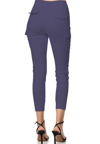 Paarse cargo broek met een slim fit ontwerp, knie-splitsingen en achterzakken, gecombineerd met zwarte gehakte sandalen. Soepele textuur en elastische manchetten.