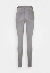 Jeans grises ajustados con una cintura alta, que cuentan con dos bolsillos traseros y una textura de denim suave. El diseño es ceñido y elegante.