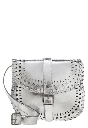 Lille metallisk sølv læder crossbody taske med en frontspænde, dekorative udskæringer og justerbar rem.