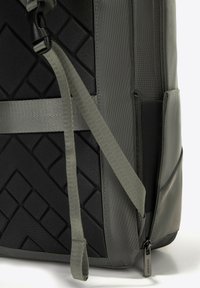 Grijze rugzak met een gestructureerd zwart paneel, verstelbare schouderbanden en een ritssluiting zak. Heeft een gestroomlijnd ontwerp en duurzame materialen.