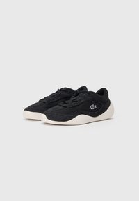 Zwarte sneakers met een mesh bovenwerk, suède accenten, een ronde zool en een witte rubberen buitenzool. Lacoste-logo aan de zijkant.