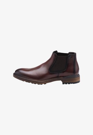 Bottines Chelsea en cuir marron avec des panneaux latéraux élastiques et un bout rond. Présente une semelle marron contrastante et une surface texturée pour une meilleure adhérence.