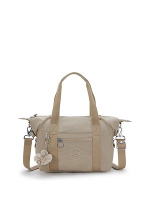 Beiget Stofftasche mit zwei Henkeln und abnehmbarem Schulterriemen, verfügt über eine vordere Reißverschlusstasche und einen daran befestigten Pelz-Pompon-Anhänger.