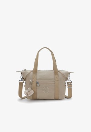 Beige fabric bag with dual handles and removable shoulder strap, features a front zipped pocket and a fur pom-pom charm attached.