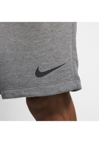 Grijze katoenen sportshorts met een soepele textuur, voorzien van een zwart Nike-logo op de zoom en een eenvoudig ontwerp.