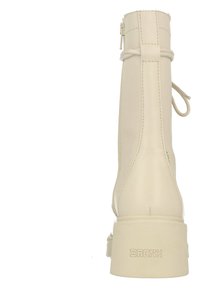 Bijenlederen enkelboot met een ronde neus, een ritssluiting aan de achterkant en een gestrikt accentdetail. Chunky hak met geëmbosseerd "BRONX" merk.