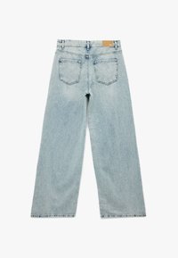 Jeans de mezclilla de tiro alto en un azul claro, de pierna ancha, con dos bolsillos traseros y una etiqueta de cuero en la cinturilla. Presenta textura desgastada.
