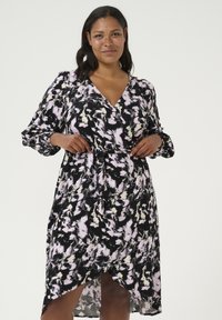 Vestido negro con un patrón floral en tonos de rosa y crema, con mangas largas, diseño cruzado y una abertura a la altura de la rodilla en la parte frontal.