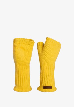 Geel gebreide vingerloze handschoenen met geribbelde manchetten en een leren merklabel. Zachte textuur en open vingertoppen voor behendigheid.