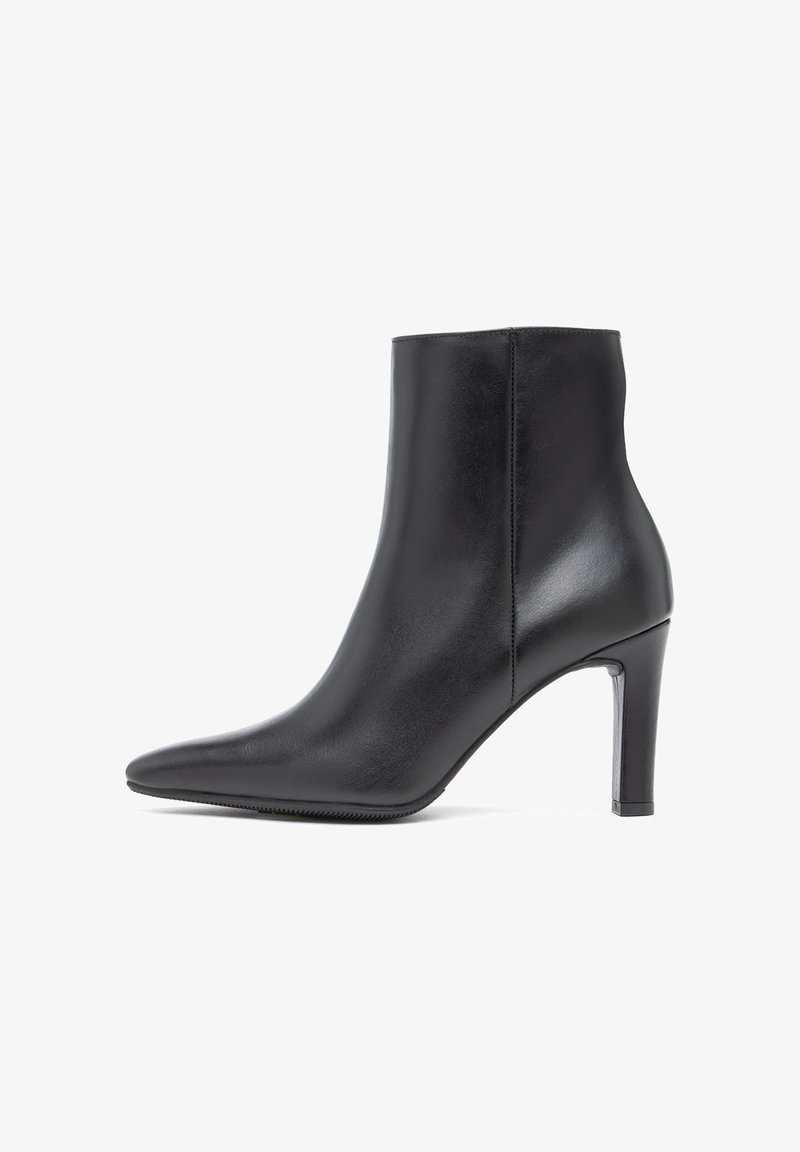Bottine en cuir noir avec bout pointu et talon fin de hauteur moyenne, vue de profil sur fond blanc.