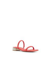Röd flat sandal med två smala remmar och en texturerad låg klack med vertikala linjer. Slätt material och minimalistisk design.