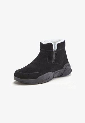 Schwarze Stiefeletten aus Wildleder mit weißem Fellfutter, seitlichem Reißverschluss und profilierter Gummisohle. Abgerundete Zehenpartie und gepolsterter Schaftrand.