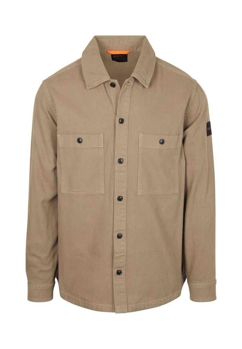 Tan button-up shirt van gestructureerde stof, met twee borstzakken, zwarte knopen en een oranje detail aan de binnenkraag.