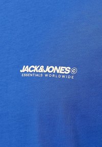 Mėlynas medvilninis T-shirt su baltu spausdintu logotipu "JACK&JONES" ir tekstu "ESSENTIALS WORLDWIDE", glotni tekstūra ir apvaliu iškirpimu.