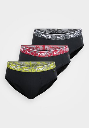 Drie paar Nike slipjes in brief-stijl, zwart met elastische banden met patroon: grijze, rode en gele camouflageontwerpen.