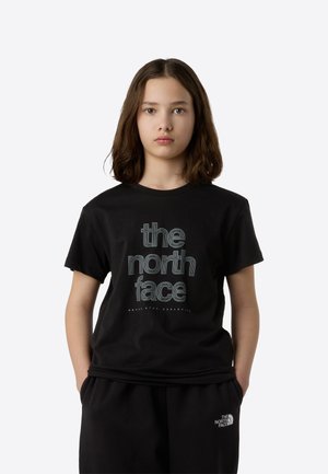Črna bombažna majica s kratkimi rokavi z velikim, grafičnim logotipom "the north face" v kontrastnem dizajnu, skupaj z ujemajočimi se črnimi hlačami.