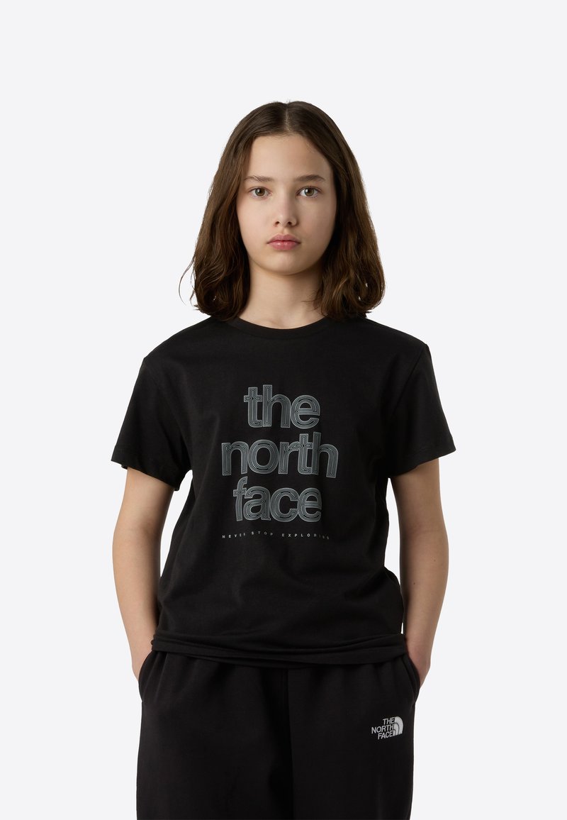 Črna bombažna majica s kratkimi rokavi z velikim, grafičnim logotipom "the north face" v kontrastnem dizajnu, skupaj z ujemajočimi se črnimi hlačami.