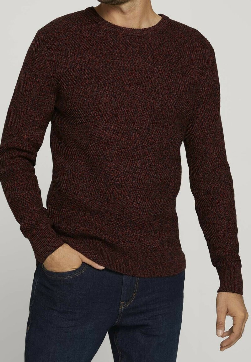 Rot und schwarz gestreifter Strickpullover mit Rundhalsausschnitt und langen Ärmeln, ausgestattet mit einem Fischgrätenmuster und gerippten Bündchen.