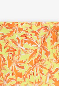 Bloemrijke stof met grote oranje bladeren op een heldergele achtergrond. Gladde textuur met een strikdetail aan één kant.