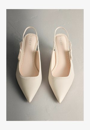 Lodičky so špicatou špičkou a pásikom vzadu v smotanovej farbe, s oblými okrajmi a dekoratívnou mašľou. Hladká vnútorná podšívka.