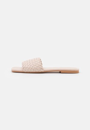 Sandale à enfiler tissée en cuir rose clair avec une semelle plate et un design à bout ouvert. Elle présente une tige tissée texturée et une semelle intérieure lisse.