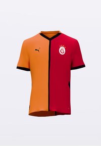 Czerwona i pomarańczowa koszulka piłkarska z krótkimi rękawami, z czarnym dekoltem w kształcie litery V, czarnymi akcentami oraz logo klubu na piersi.