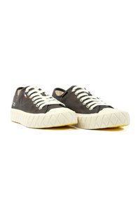 Czarne płócienne tenisówki z białymi sznurówkami, teksturowana guma z wzorem w diamenty na podeszwie oraz żółty akcent na dole.