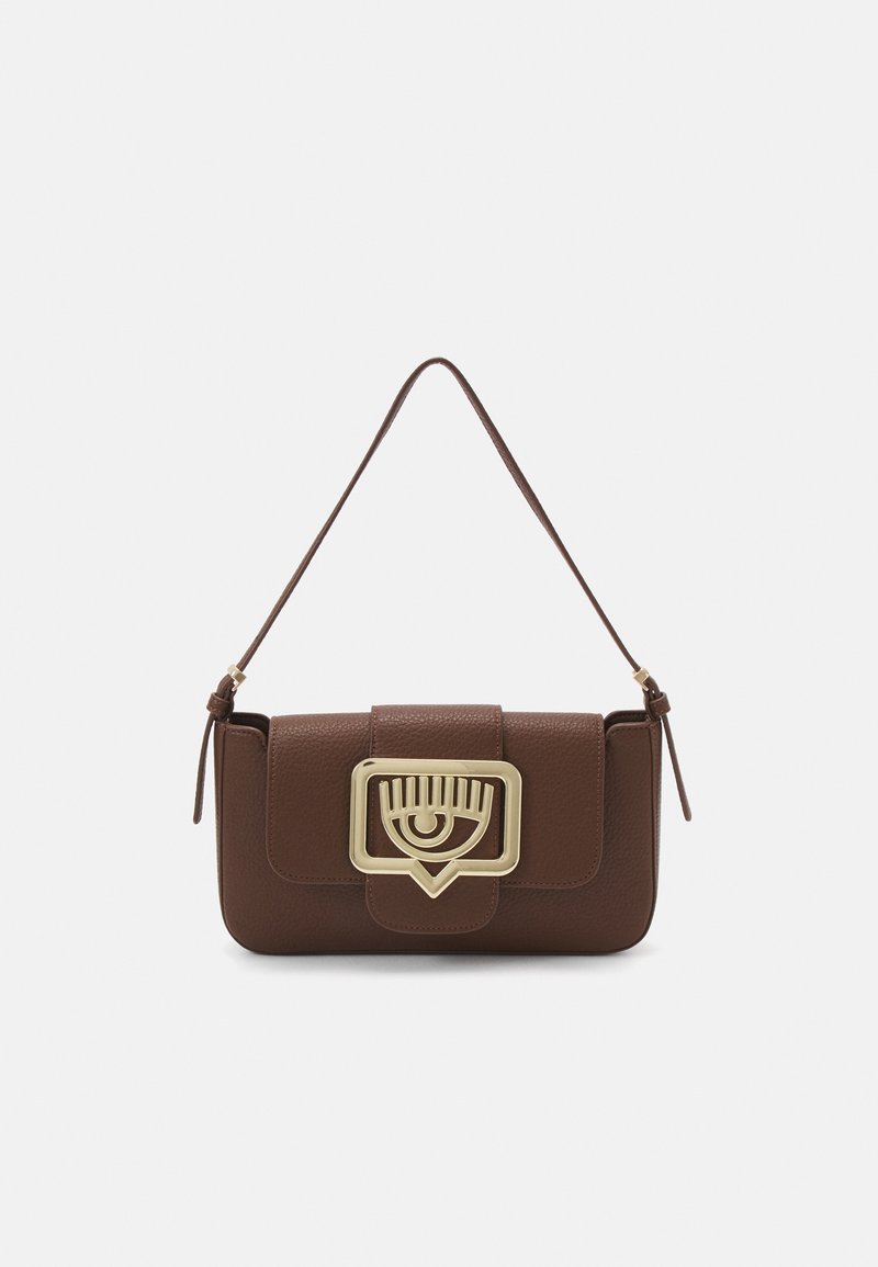 Sac à main en cuir marron avec un fermoir en forme d'œil en ton doré, corps rectangulaire et une sangle ajustable fine. La surface texturée ajoute du détail.