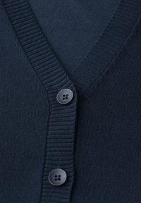 Granatowy sweter z dzianiny z dekoltem w literę V, prążkowanym wykończeniem i trzema guzikami. Miękka faktura oraz dopasowany krój.