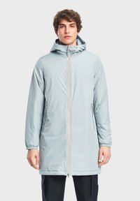 Cappotto lungo azzurro chiaro con cappuccio, dotato di zip frontale, polsini elastici e tasche laterali, realizzato in tessuto liscio e resistente all'acqua.