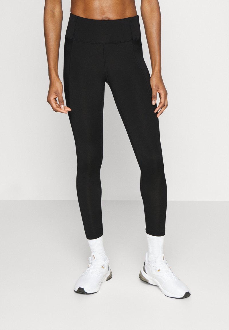 Černé legíny s vysokým pasem, vyrobené z elastického materiálu. Nosit s bílými sportovními botami a ponožkami. Čistý a jednoduchý design.