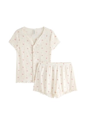 Miękki biały prążkowany top z krótkim rękawem, zapinany na guziki, oraz pasujące szorty z elastyczną talią, oba ozdobione małym różowym kwiatowym wzorem i falistym wykończeniem.