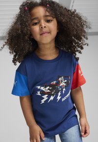 Blå og rød T-shirt med korte ærmer, prydet med et grafisk motiv af en racerbils, med lynmotiver og et logo på venstre ærme.