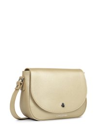Beige leren crossbodytas met een gladde textuur, afgeronde klep, zilverkleurige hardware en een reliëf merklogo aan de voorkant.
