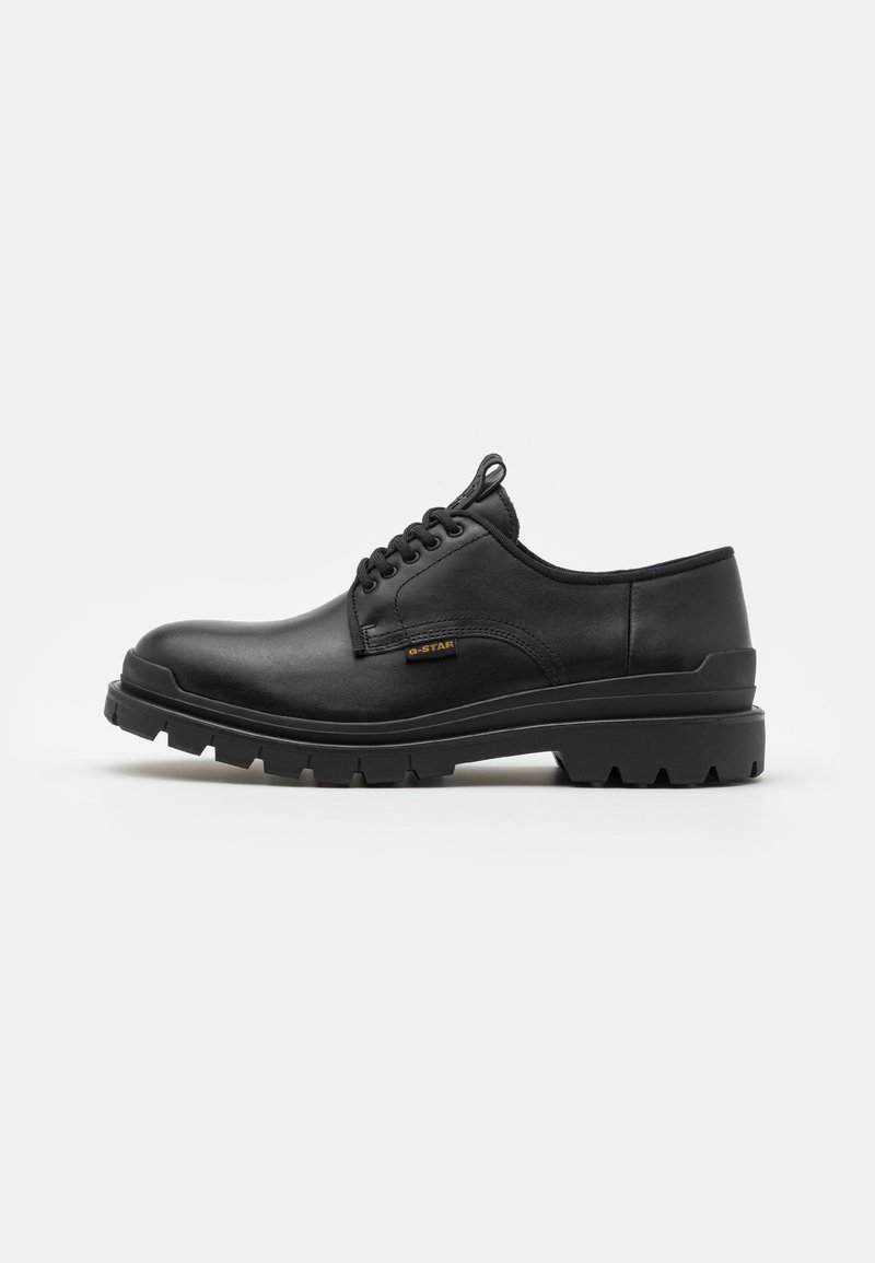 Chaussure à lacets en cuir noir avec semelle épaisse crantée et petite étiquette "G-STAR" sur le côté, présentée de profil sur un fond uni.