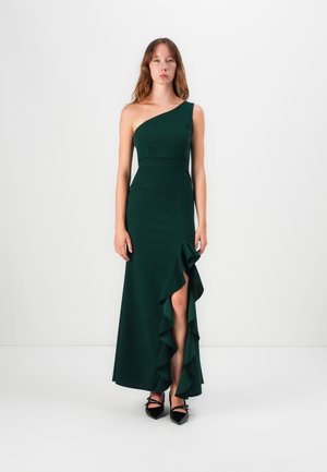 One-shoulder green dress with a fitted bodice, ruffled detail along the hem, and a side slit. Made of smooth fabric, ankle-length.