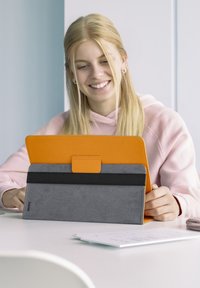 Tablettasche aus orangefarbenem und grauem synthetischem Material, mit einem faltbaren Design und einer strukturierten Oberfläche sowie einem schwarzen Akzentband.