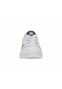 Zapatilla blanca con parte superior de cuero suave, cierre de cordones y un acento gris contrastante en la lengua. Suela plana con un sutil detalle de costura.