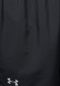 Svart tyg med en liten, ljusgrå Under Armour-logotyp nära det nedre hörnet.