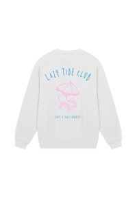 White sweatshirt featuring a pink beach umbrella and chair graphic. "LAZY TIDE CLUB" text in blue arches over the design. Soft fabric texture.