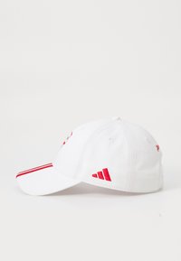 White cap made of fabric with a curved visor, featuring red accents and logo. Red stripes run along the visor, enhancing the design.
