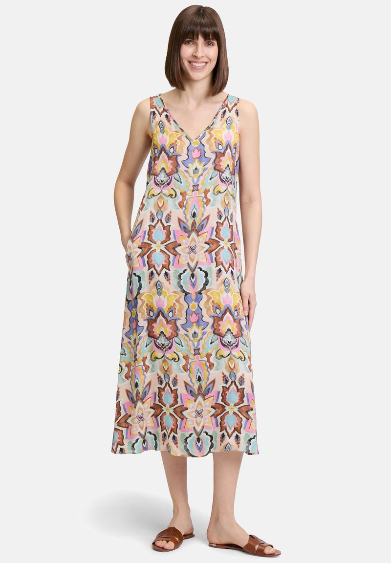 Robe maxi en tissu léger avec un motif floral coloré dans des tons de rose, marron et bleu. Encolure en V et poches sur les côtés.