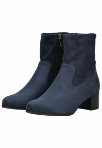 Une paire de bottes de cheville en daim bleu marine avec des talons carrés et des zippers sur les côtés, présentée de biais sur un fond blanc.