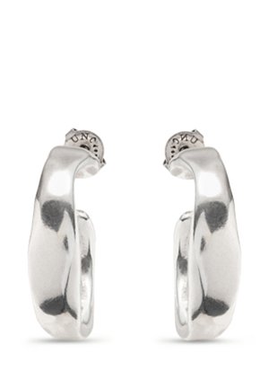 Boucles d'oreilles à anneaux épais en argent poli avec une forme légèrement irrégulière et organique, dotées de fermoirs à tige.