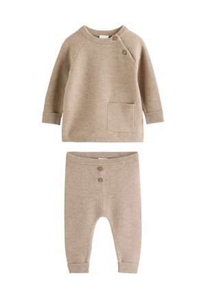 Beige strikket babyoutfit med langærmet top med to skulderknapper og frontlomme, kombineret med matchende bukser med to forreste knapper.