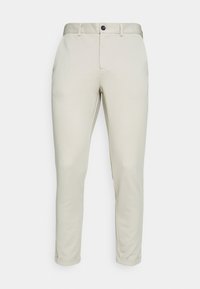Pantalon beige slim fit pour homme avec passants de ceinture, bouton à l'avant, fermeture éclair et ourlets retroussés sur fond uni.